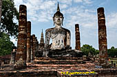 Thailand, Old Sukhothai - Wat Mahathat, the vihan with a seated Buddha statue. 